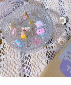 Close-up of cute cartoon hair clips including bear and cloud shapes in a glass jar