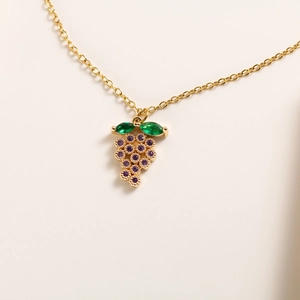 Close-up of gold grape pendant with purple round crystals and green marquise leaves