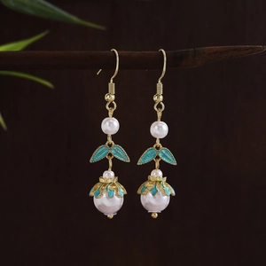 Detail of vintage Chinese earrings with white pearls and green enamel lily of the valley