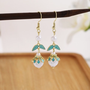 Detail of vintage beaded earrings with green oil drip charms on a wooden display