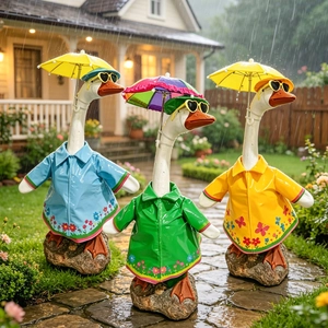 Detailed view of three porch goose ornaments wearing colorful raincoats and tiny hats