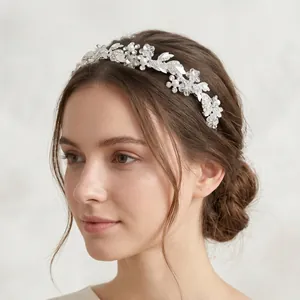 Detalle de diadema para novia con pedrería brillante, flores blancas y perlas
