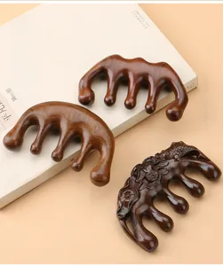 Close-up of three sandalwood meridian massage combs with smooth five-tooth design and floral carvings