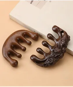 Detailed close-up of sandalwood massage combs with lotus koi carving and smooth wood grain