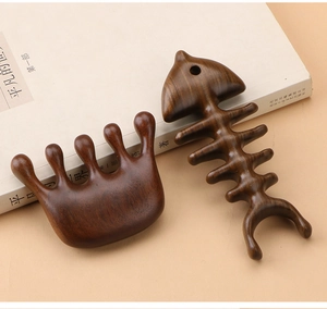 Macro shot of two dark sandalwood massage tools showing natural wood grain and smooth texture