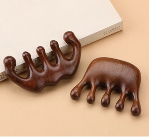 Close-up of polished sandalwood scalp massage combs with smooth rounded teeth and natural grain