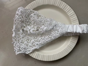 Detail of white lace headband with elegant pearls and sparkling rhinestones