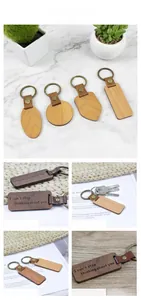 Detailed view of laser-engraved walnut and cherry wood keychains with leather accents