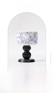 Detailed view of blue and white floral ceramic soy candle jar on a black gourd-shaped stand