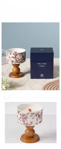 Detail of ceramic candle with red floral pattern and wooden base in premium gift box