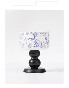 Detailed view of the blue and white floral porcelain bowl on a sleek black matte base