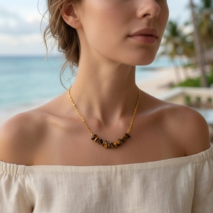 Close-up of bohemian gold chain necklace with natural tiger's eye stone chips on model
