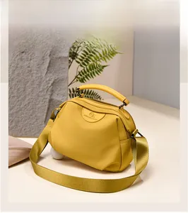 Detail view of ginger yellow waterproof oxford nylon handbag with wide strap and logo