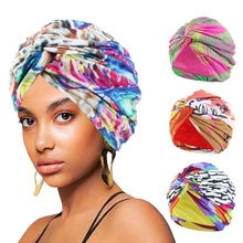 Detail showing various colorful floral and zebra print turbans with pleated ethnic design