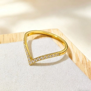 Makroaufnahme des goldenen V-förmigen Rings mit fein besetzten weißen Zirkoniasteinen