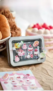 Detail of a mini metal tin box with clear window and strawberry foam stickers