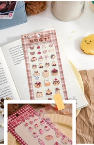 Detail of cute 3D foam dessert stickers featuring bears and strawberry cake on an open book