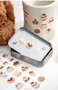 Macro shot of cute dessert foam stickers decorating a metal tin and ceramic mug