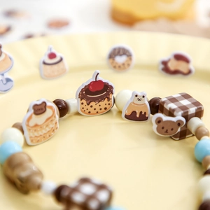 Cute dessert-themed beaded bracelet featuring cherry cake and Lucky pudding charms