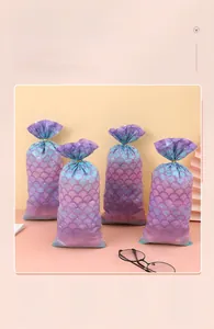 Close-up of mermaid scale pattern candy bags in purple and teal gradient with gold ties
