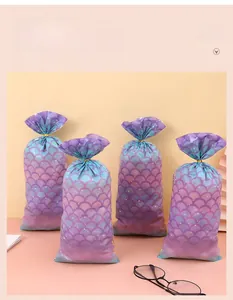 Detail view of purple and cyan gradient mermaid scale gift bags with gold ties