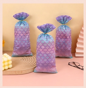 Detail showing mermaid scale pattern gradient gift bags with golden twist ties