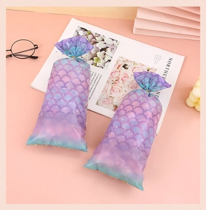 Detail of mermaid scale pattern gift bags with golden twist ties for candy and snacks