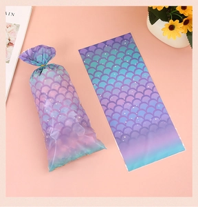 Detail of gradient mermaid scale pattern plastic bags with gold twist ties and snacks