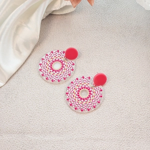 Detail of summer blue floral oil painting earrings with pink and white polka dot patterns