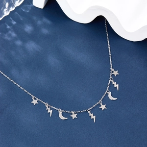 Detailed view of S925 silver necklace featuring star and moon charms on a blue background