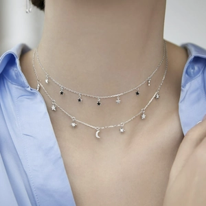 Close-up of S925 silver layered necklace with sparkling star and moon pendants with zircon