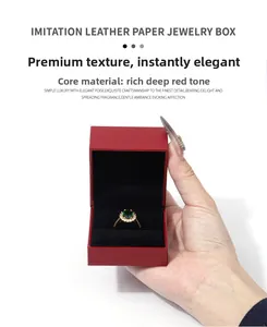 Vue rapprochée d'un écrin à bijoux rouge en simili cuir avec une bague en émeraude
