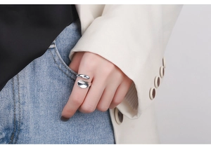Close-up of minimalist S925 silver irregular open ring worn on finger with glossy finish