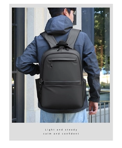 Outdoor view of a minimalist business backpack with dual front zipper pockets