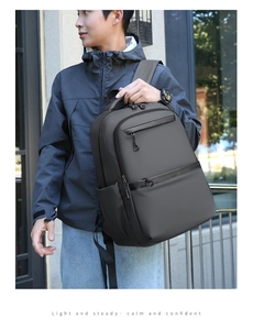 Outdoor view of a dark grey business backpack showing waterproof fabric and large capacity