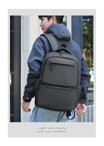 Detailed view of dark grey business backpack with waterproof matte fabric and dual front zippers
