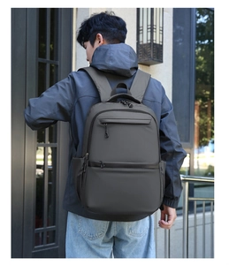 Detail of ergonomic padded shoulder straps on a large capacity dark grey business backpack