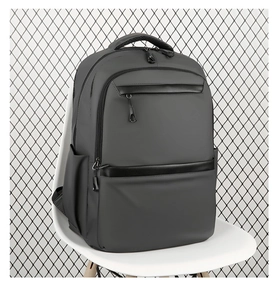 Detailed side view of matte gray business laptop backpack with black leather accents