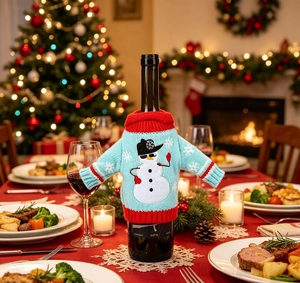 Close-up of sky blue knitted wine bottle cover with snowman and snowflake patterns