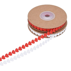 Detail of red and white heart-shaped ribbon lace trim wound on cardboard spools