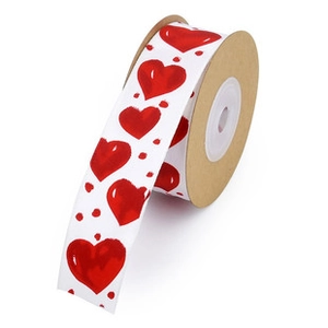 Macro detail of white ribbon roll with red heart and dot prints on cardboard spool