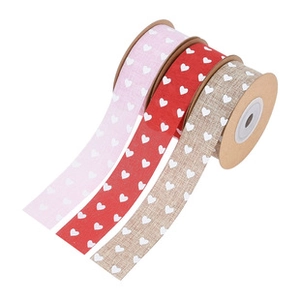 Close-up of heart print ribbon set in pink, red and beige on brown cardboard spools