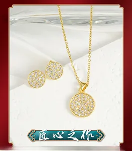 Macro detail of gold jewelry set with round pavé zircon pendant and matching earrings