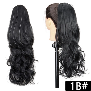 Detail view of long wavy 1B natural black ponytail extension with claw clip attachment