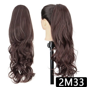 Detail view of long wavy ponytail extension in dark brown with claw clip structure