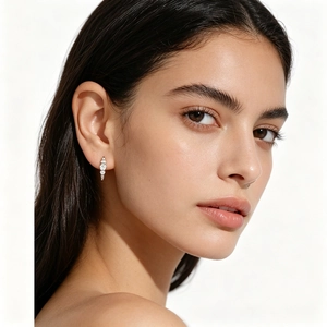 Close-up of S925 silver earrings with three vertical round zircons on model ear