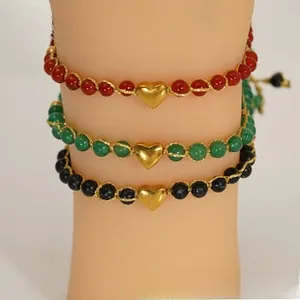 Three-piece beaded bracelet set with gold heart charms in red, green, and black cords