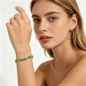 Close-up of a green natural stone beaded bracelet worn on a female wrist in detail