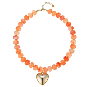 Vista dettagliata di una collana di perle di resina arancione con cuore d'oro grande.