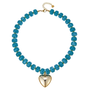 Dettaglio di una collana estiva in resina con perline blu e pendente a cuore dorato lucido